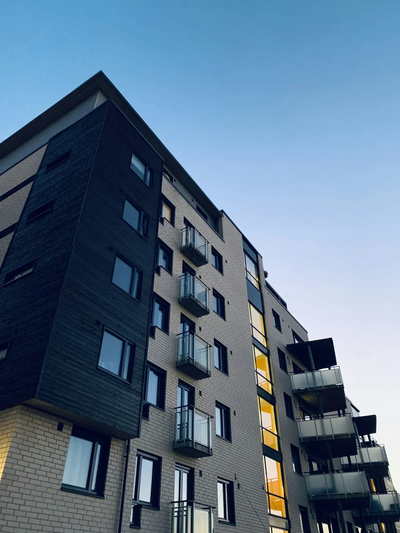 An apartment block with rows of balconies at twilight, each one a separate unit and lease