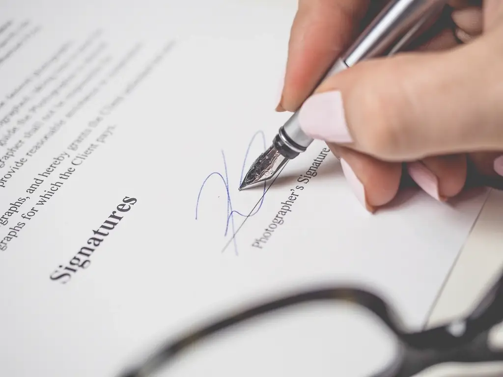 A pen resting on the signature line of a document, the moment a payment certificate is signed