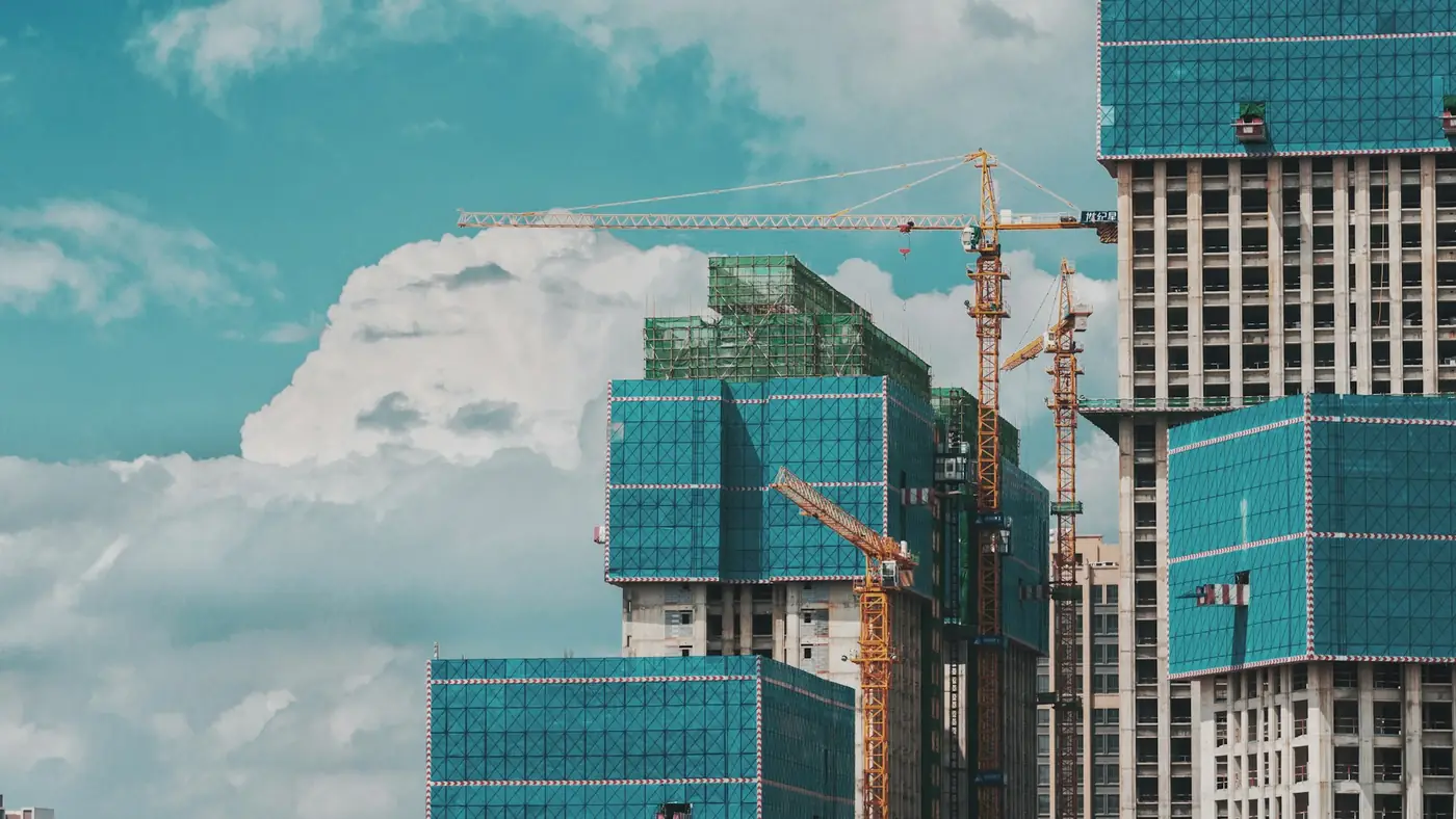 Residential towers rising under tower cranes, the scale of work most contractors still administer on paper